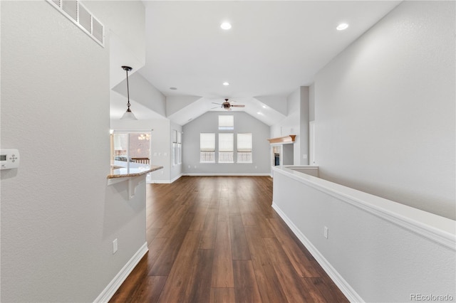 corridor with visible vents, lofted ceiling, dark wood finished floors, recessed lighting, and baseboards