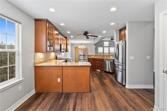 kitchen featuring a wealth of natural light, appliances with stainless steel finishes, and a peninsula