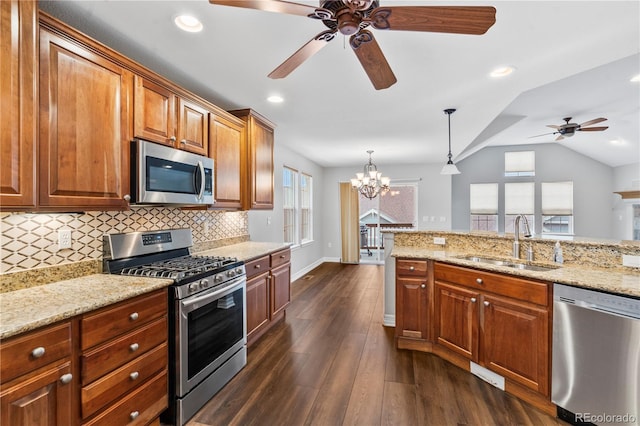 kitchen featuring a sink, light stone counters, tasteful backsplash, appliances with stainless steel finishes, and vaulted ceiling