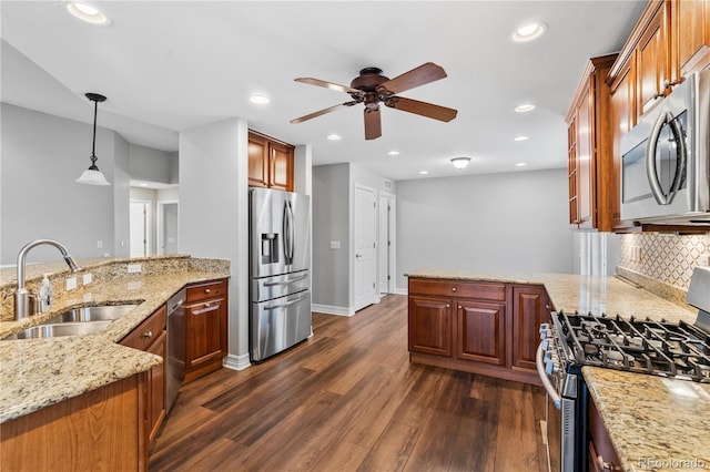 kitchen featuring decorative backsplash, appliances with stainless steel finishes, a peninsula, dark wood-style floors, and a sink