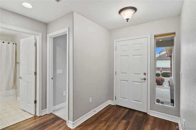 foyer entrance with dark wood finished floors and baseboards