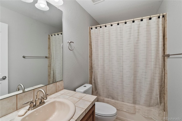 bathroom with vanity, toilet, a textured wall, and shower / bath combo