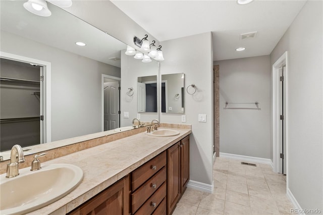 bathroom featuring a sink, visible vents, baseboards, and tile patterned floors