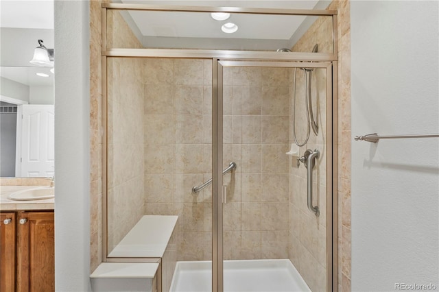 bathroom with a shower stall and vanity