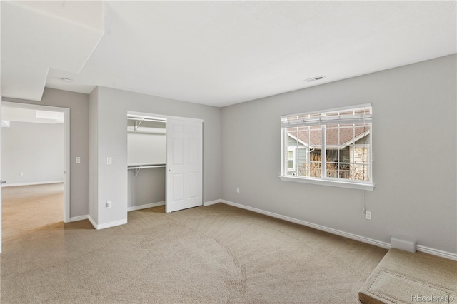 unfurnished bedroom featuring a closet, visible vents, carpet, and baseboards