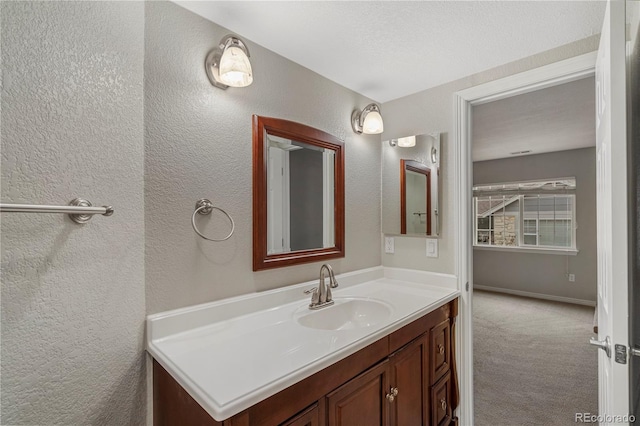 bathroom with vanity and a textured wall