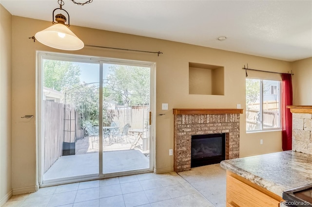 2035 Overland Dr, Brighton, CO 80601 - doorway to outside featuring a fireplace, plenty of natural light, and light tile patterned flooring