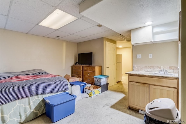 2035 Overland Dr, Brighton, CO 80601 - bedroom with freestanding refrigerator, light colored carpet, a sink, and a drop ceiling
