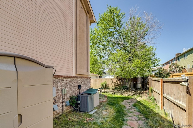 2035 Overland Dr, Brighton, CO 80601 - view of home's exterior with a fenced backyard, central AC, and brick siding