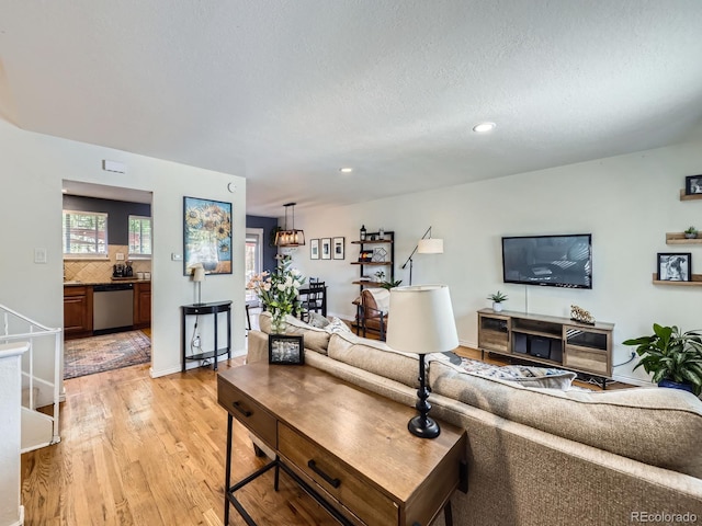 6664 Gray St, Arvada, CO 80003 - living area with light wood-style flooring, recessed lighting, and a textured ceiling