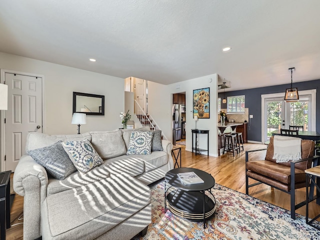 6664 Gray St, Arvada, CO 80003 - living area featuring light wood finished floors, stairway, and recessed lighting