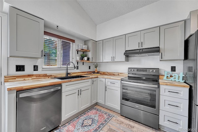 4726 S Taft St, Morrison, CO 80465 - kitchen with stainless steel appliances, butcher block counters, under cabinet range hood, lofted ceiling, and gray cabinetry