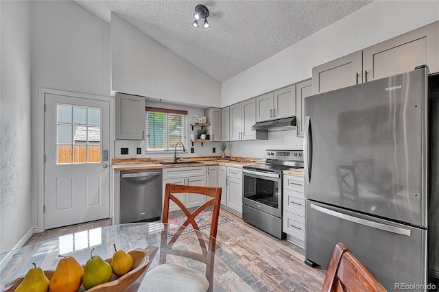4726 S Taft St, Morrison, CO 80465 - kitchen featuring appliances with stainless steel finishes, gray cabinets, a textured ceiling, under cabinet range hood, and high vaulted ceiling
