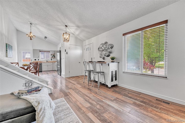 4726 S Taft St, Morrison, CO 80465 - living room with a textured ceiling, a chandelier, wood-type flooring, and lofted ceiling