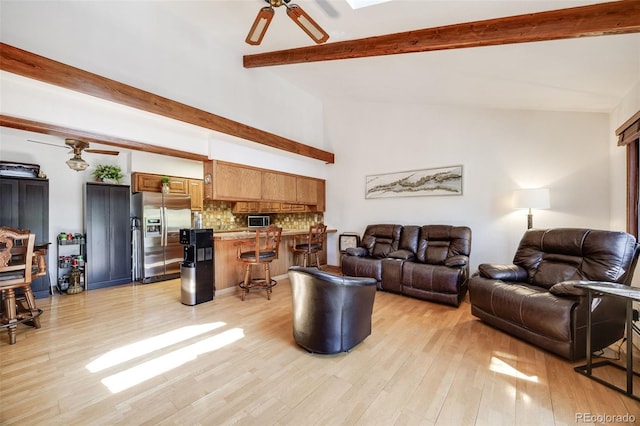 living room with light wood-style floors, ceiling fan, and vaulted ceiling with beams