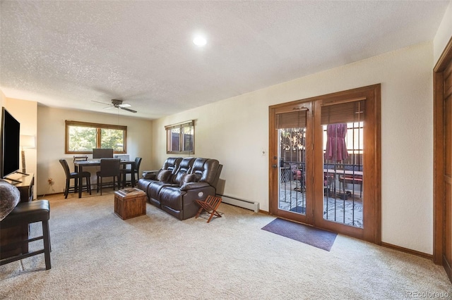 living area with light carpet, baseboards, ceiling fan, a textured ceiling, and a baseboard heating unit