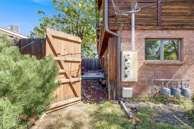 view of side of home with brick siding and fence private yard