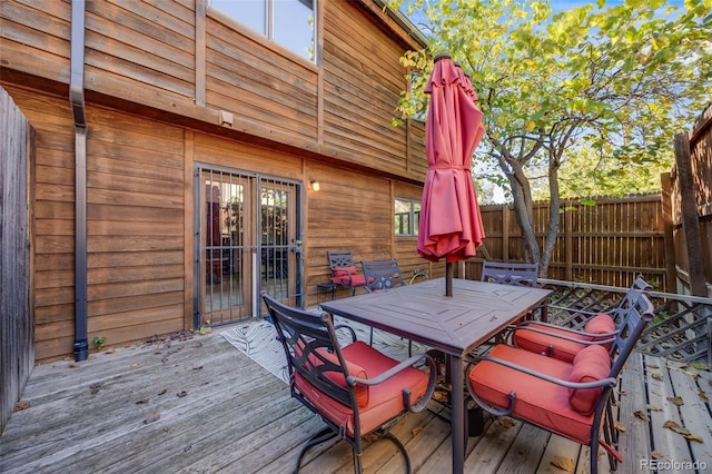 wooden terrace featuring fence and outdoor dining space