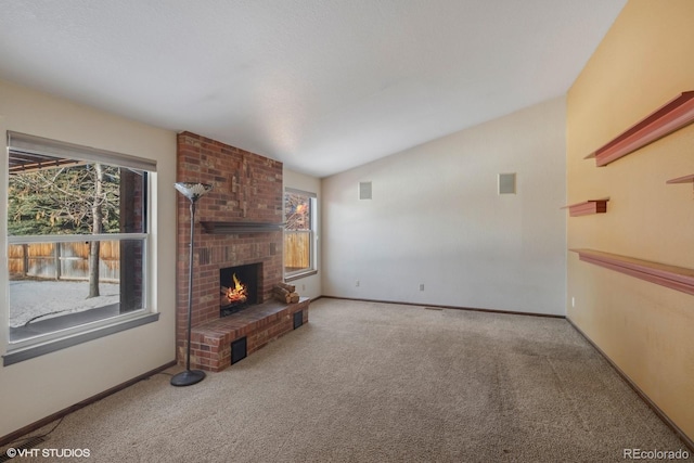 carpeted living room with a fireplace and vaulted ceiling