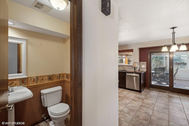 bathroom with tile patterned floors, sink, a textured ceiling, and toilet