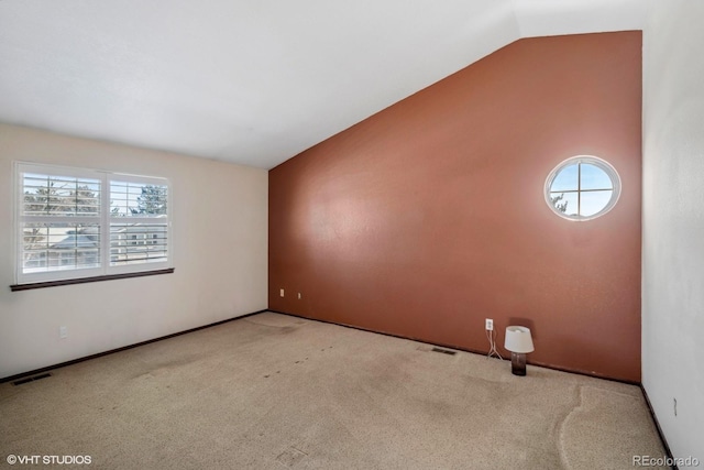 carpeted spare room featuring a wealth of natural light and lofted ceiling