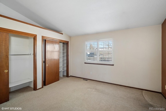 unfurnished bedroom with light colored carpet and vaulted ceiling