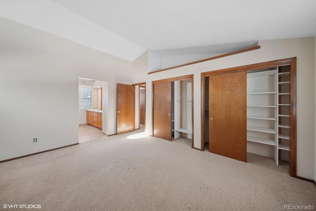 unfurnished bedroom with lofted ceiling and light carpet