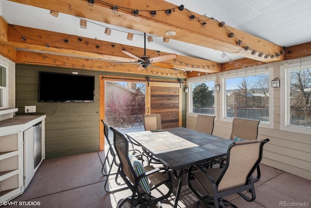 sunroom with ceiling fan and a barn door