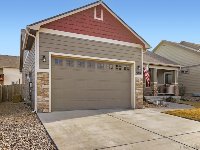 view of front facade featuring stone siding, covered porch, driveway, and a garage