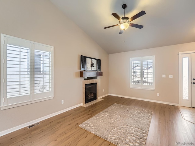 unfurnished living room featuring a fireplace, wood finished floors, visible vents, and a ceiling fan