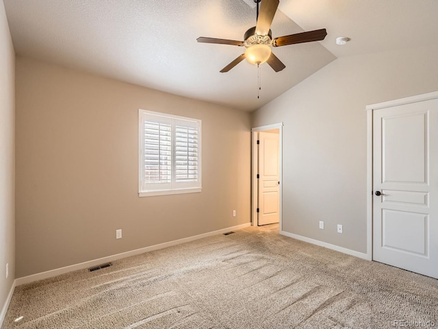 unfurnished bedroom with ceiling fan, carpet flooring, visible vents, baseboards, and vaulted ceiling