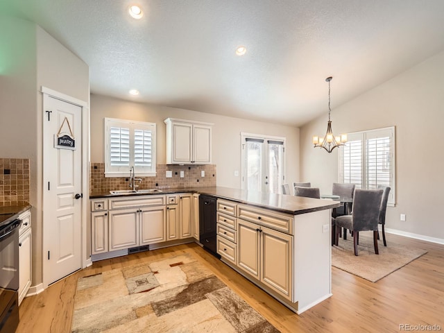 kitchen featuring decorative backsplash, dark countertops, an inviting chandelier, vaulted ceiling, and a sink