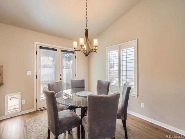 dining area featuring vaulted ceiling, french doors, wood finished floors, and baseboards