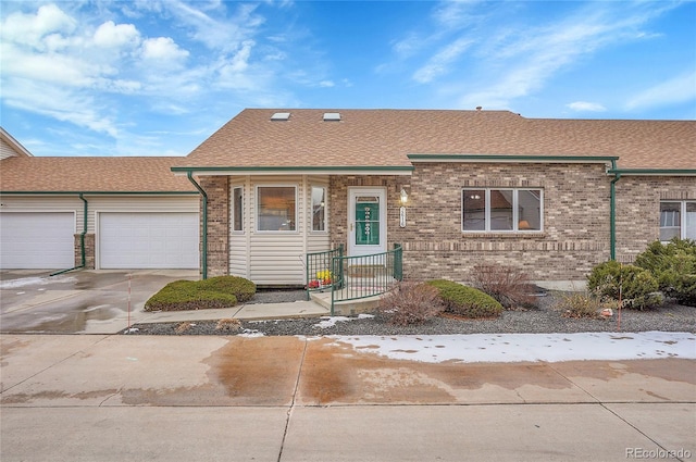 view of front of property featuring a garage, concrete driveway, brick siding, and a shingled roof