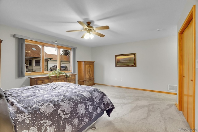 bedroom with baseboards, a ceiling fan, visible vents, and light colored carpet