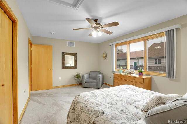 bedroom with baseboards, visible vents, a ceiling fan, and light colored carpet