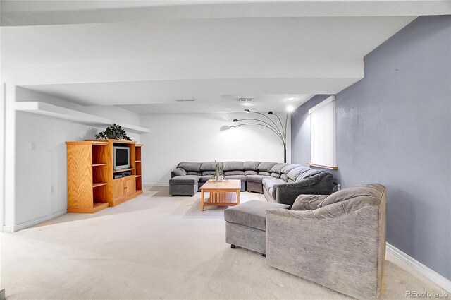 living area featuring baseboards, visible vents, and light colored carpet