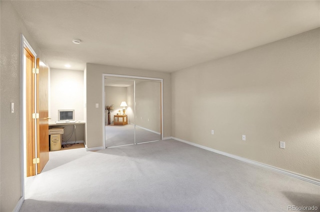 bedroom featuring a closet, light carpet, and baseboards