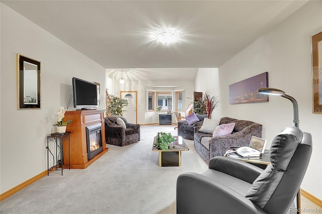 carpeted living area with a glass covered fireplace and baseboards