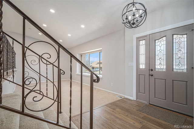 entrance foyer featuring stairway, wood finished floors, visible vents, recessed lighting, and a notable chandelier