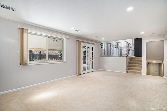 spare room with visible vents, carpet flooring, stairway, and baseboards