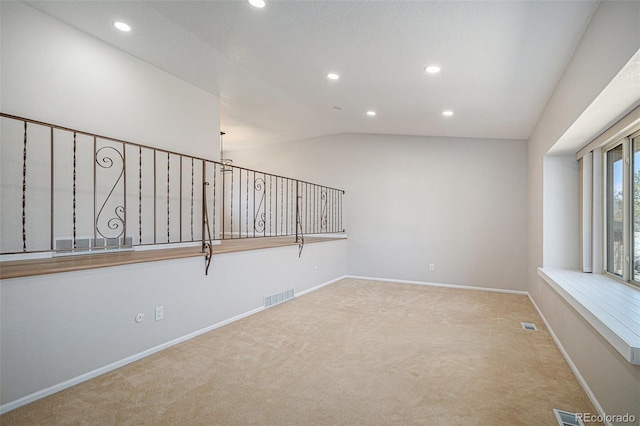 carpeted empty room featuring visible vents, recessed lighting, baseboards, and vaulted ceiling