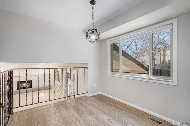 spare room with visible vents, baseboards, and wood finished floors