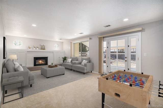 living room with recessed lighting, carpet, a fireplace, and a textured ceiling