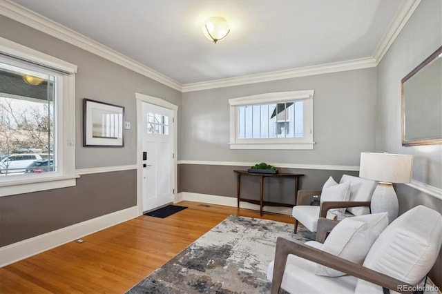 foyer entrance with a healthy amount of sunlight, crown molding, baseboards, and wood finished floors