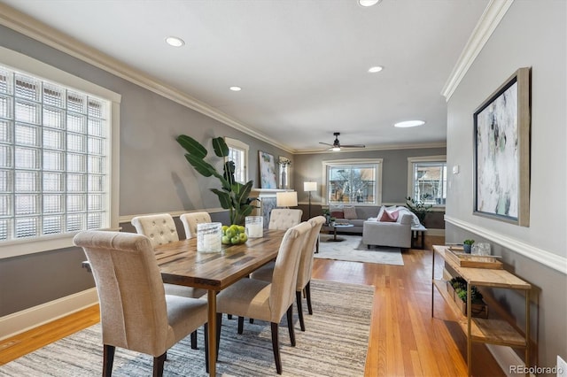 dining room with light wood-style floors, baseboards, ornamental molding, and recessed lighting