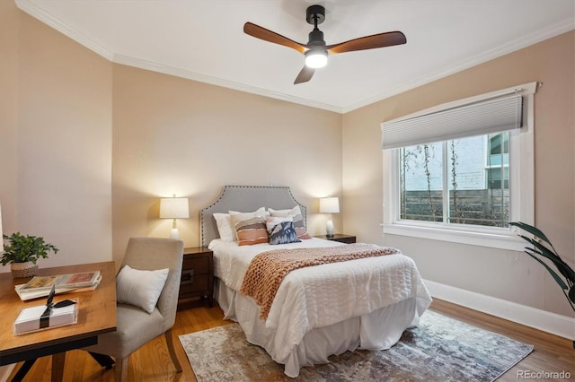 bedroom with baseboards, ceiling fan, wood finished floors, and crown molding