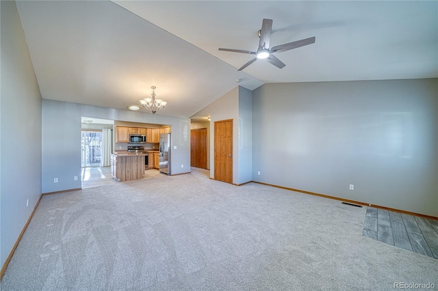 unfurnished living room featuring light carpet, vaulted ceiling, and ceiling fan with notable chandelier