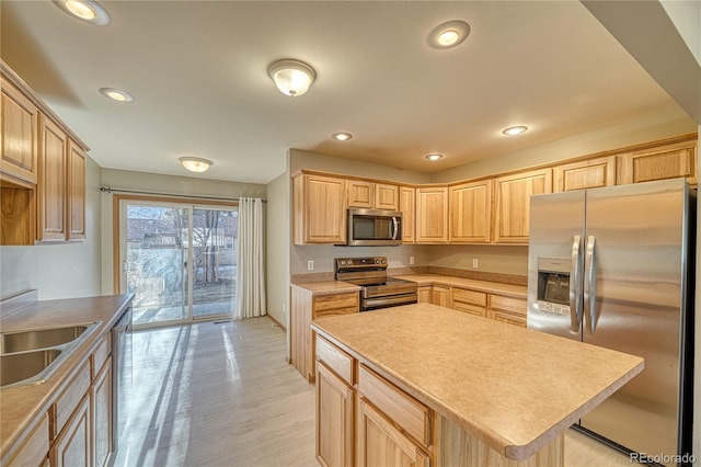 kitchen featuring a kitchen island, sink, light hardwood / wood-style flooring, light brown cabinets, and stainless steel appliances