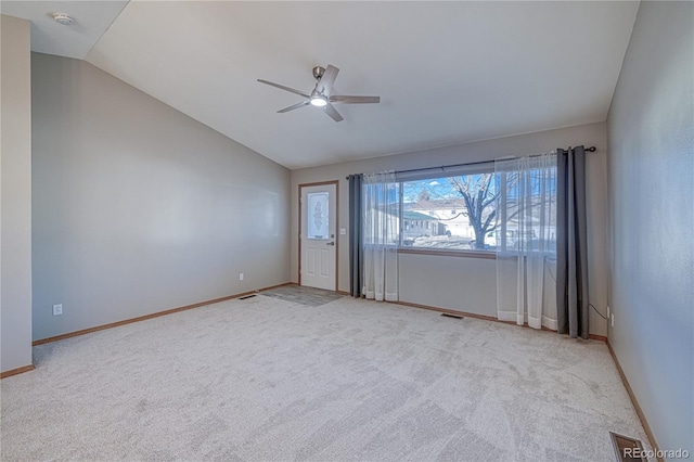 carpeted spare room with ceiling fan and lofted ceiling